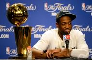 Dwyane Wade #3 of the Miami Heat smiles next to the Larry O'Brien Finals Championship trophy.